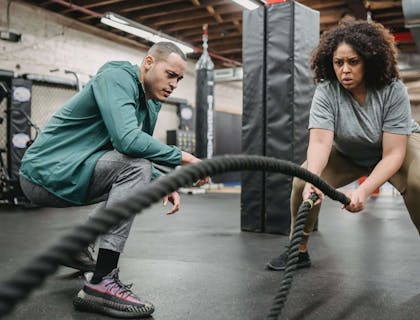 Une coach de santé travaillant avec un client dans une salle de sport.