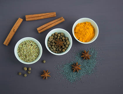 Eine Auswahl an Kräutern und Gewürzen liegt auf einem Tisch.