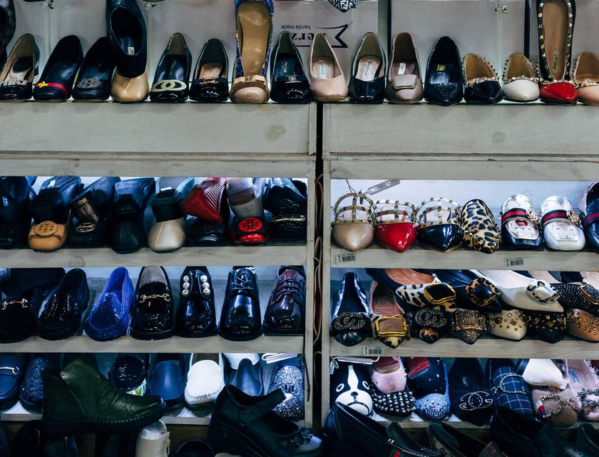 Zapatos y botas de dama exhibidos en los estantes de una zapatería.