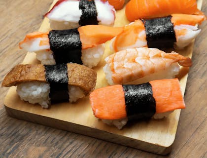 Un platillo servido en una bandeja de madera en un restaurante de sushi.