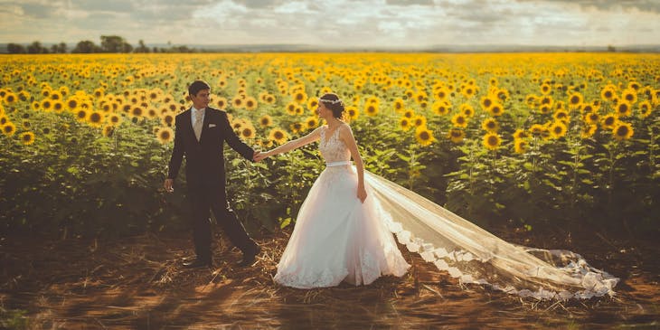 Una pareja de novios en un campo de girasoles.