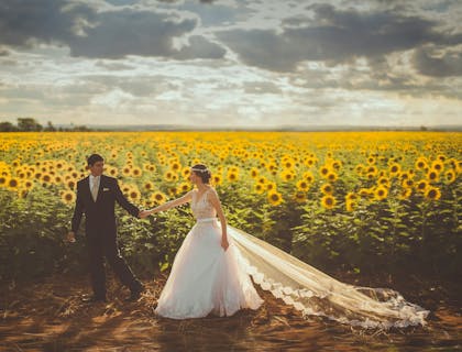 Una pareja de novios en un campo de girasoles.