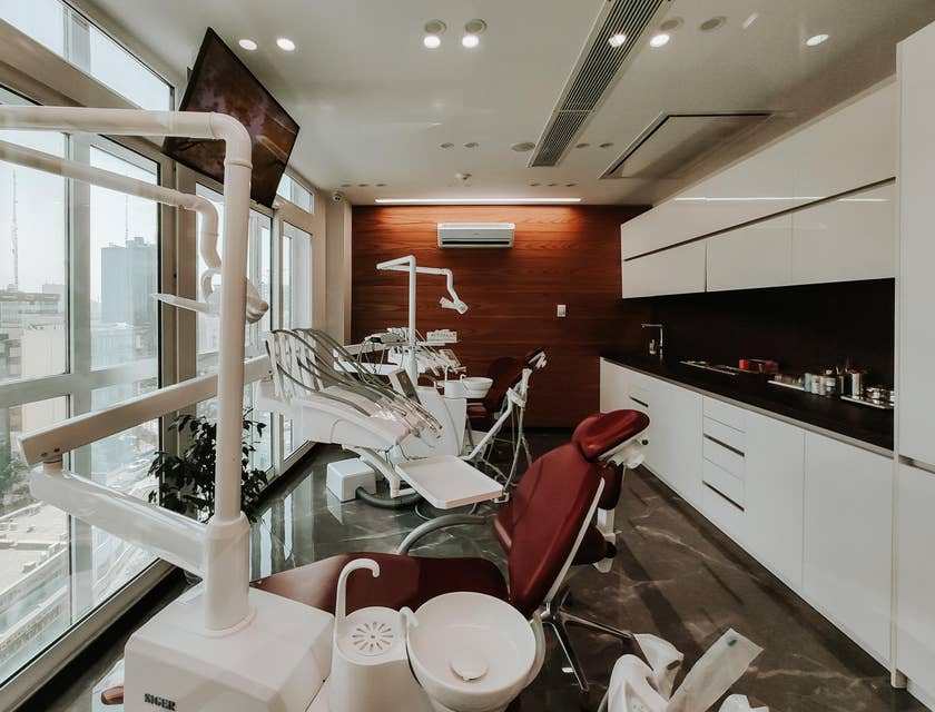 Interior de una clínica odontológica con varias unidades dentales e instrumental odontológico.