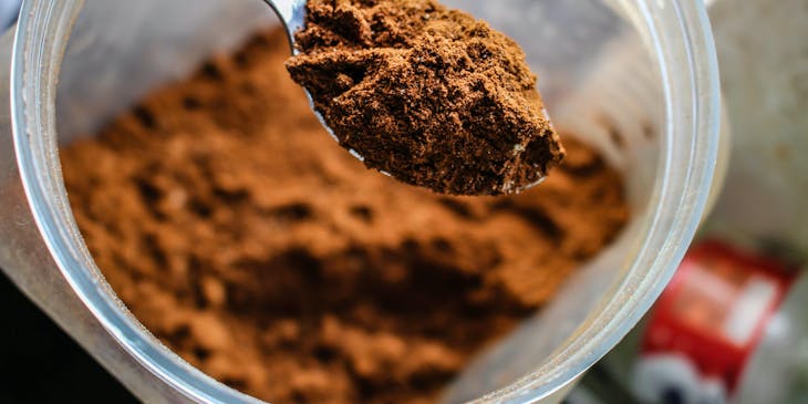 Cuchara llena de cacao en polvo en una empresa de cacao.
