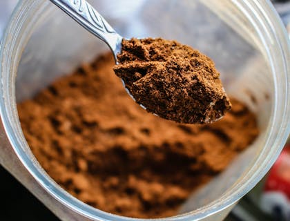 Cuchara llena de cacao en polvo en una empresa de cacao.