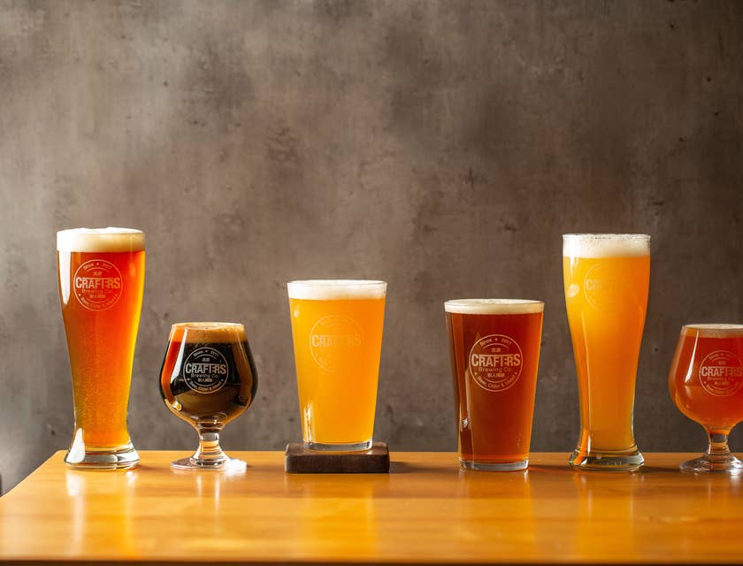 Seis vasos cerveceros servidos con distintas cervezas de una empresa de cerveza artesanal.