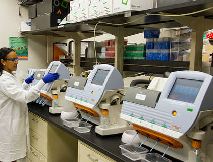 Laboratorista operando un equipo de análisis clínico en un laboratorio clínico.