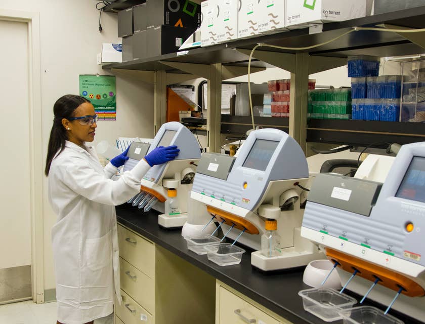 Laboratorista operando un equipo de análisis clínico en un laboratorio clínico.