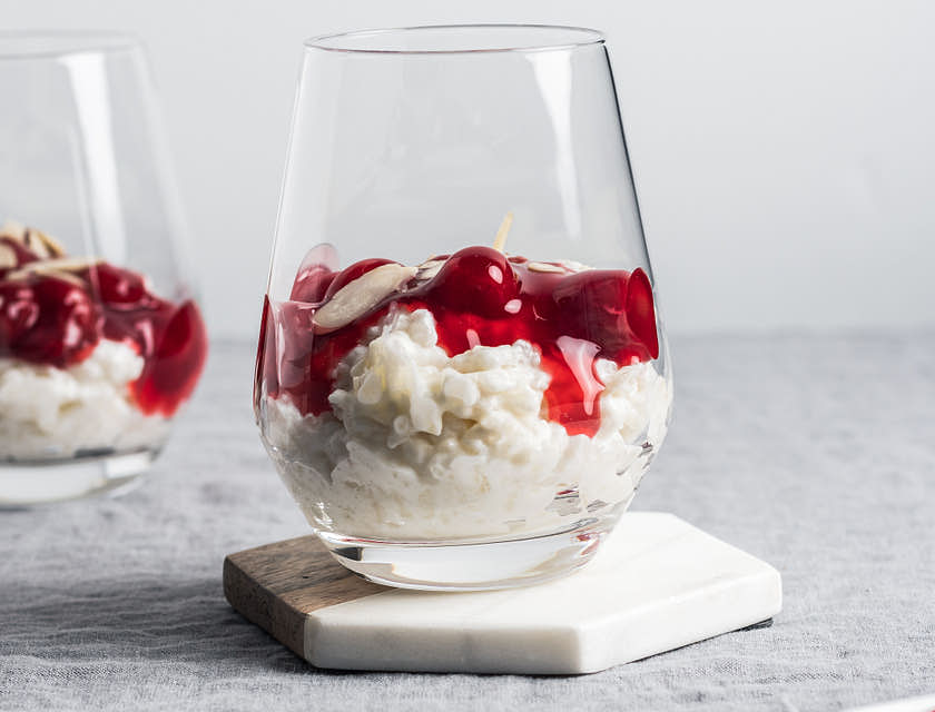 Arroz con leche servido con mermelada de cereza en un vaso de vidrio en un negocio de arroz con leche.
