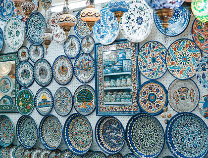 Platos de distintos tamaños, lámparas y un espejo en un negocio de artesanías de Olinalá.