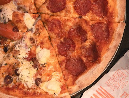 Rebanadas de pizza estilo Nueva York de dos ingredientes sobre una mesa.