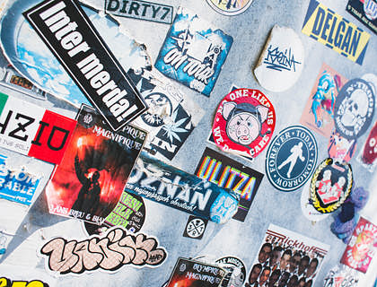 Muchos rótulos pegados en una pared en un negocio de rótulos.