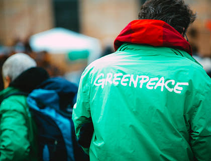 Activista de una organización ambiental vistiendo una chamarra de color verde con el nombre de Greenpeace.