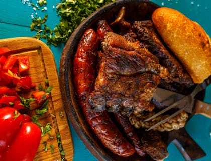 Un asado servido junto a unos pimientos rebanados en un restaurante uruguayo.