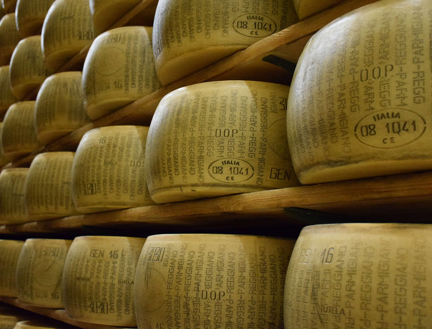 Uno scaffale pieno di forme di Parmigiano Reggiano in un caseificio.