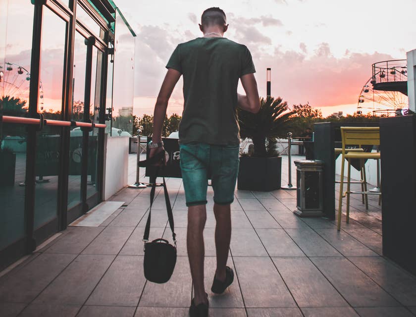 Un homme avec sa sacoche en train de marcher sur une terrace.