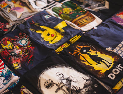 Une table avec plusieurs t-shirts aux dessins floqués.