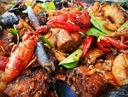 Un plat de fruits de mer épicé avec langoustes, crevettes et moules.