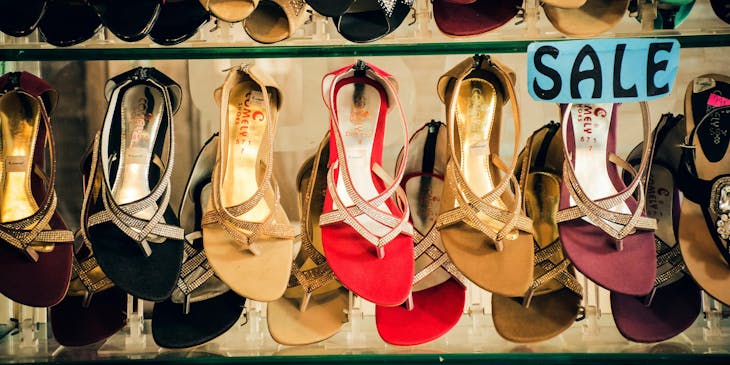 Lines of shoes on a shelf in a shoe store.