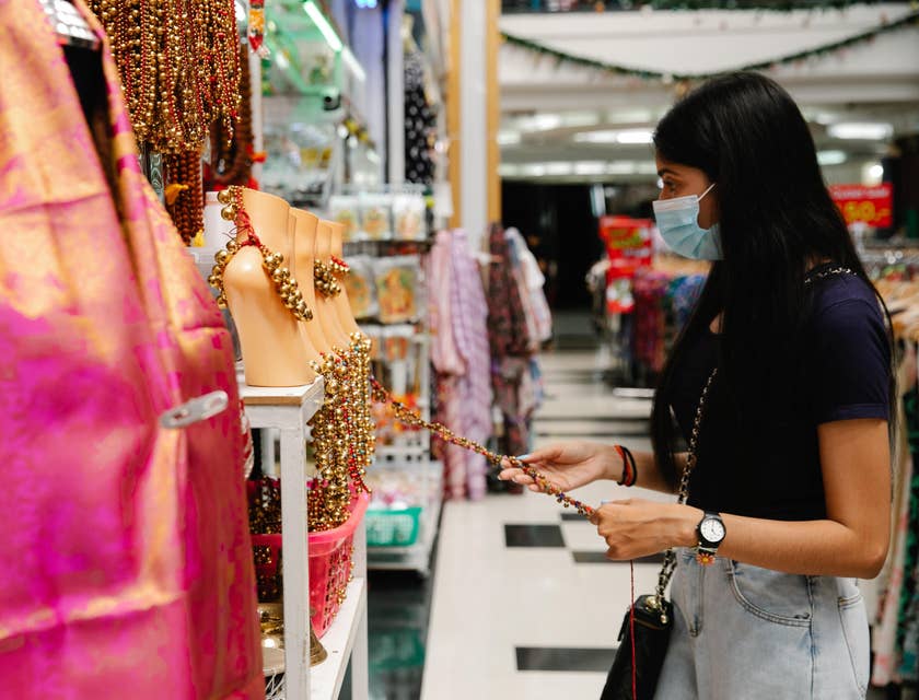 A woman wearing a mask shopping at a retail store.