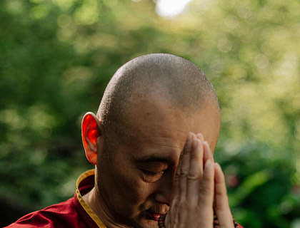 A spiritual coach demonstrating a prayer position.