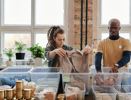 A man and a woman searching through items at a thrifty business.