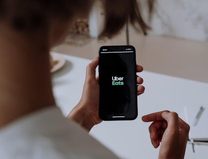 Una persona que pide comida en un restaurante virtual a través de la aplicación móvil Uber Eats.