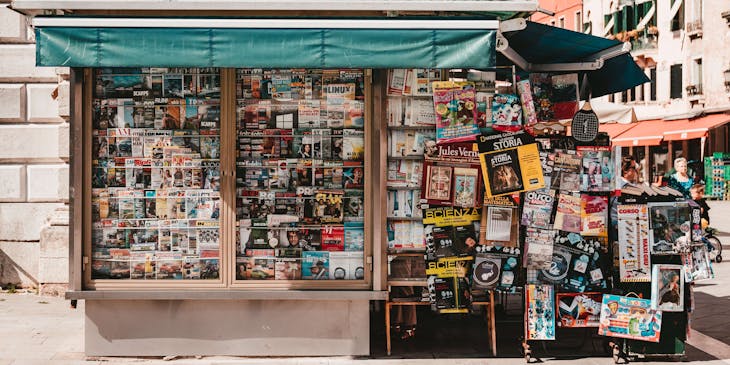 Un'edicola con riviste e quotidiani sull'angolo di una strada.