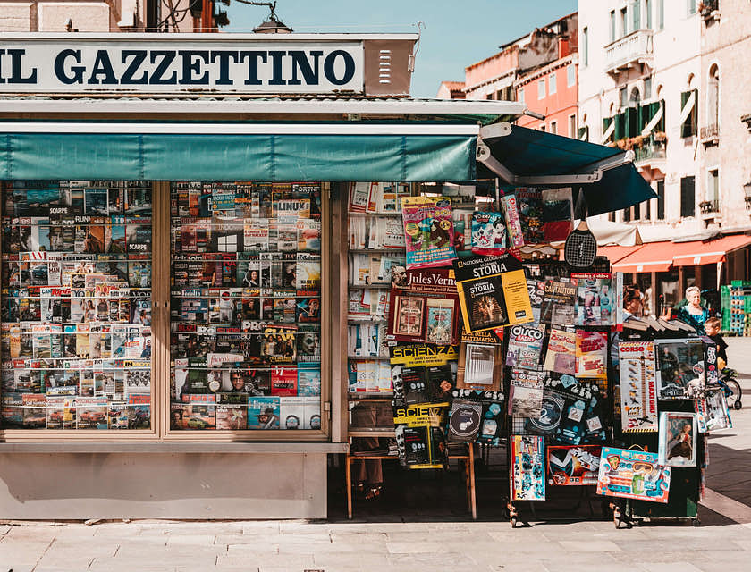 Un'edicola con riviste e quotidiani sull'angolo di una strada.