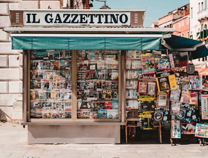Un'edicola con riviste e quotidiani sull'angolo di una strada.