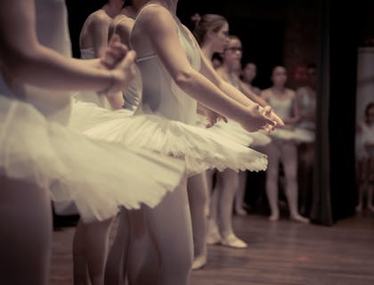 Una fila de bailarinas de ballet en una academia de baile.
