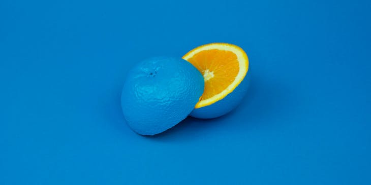 A painted blue lemon sliced in two.