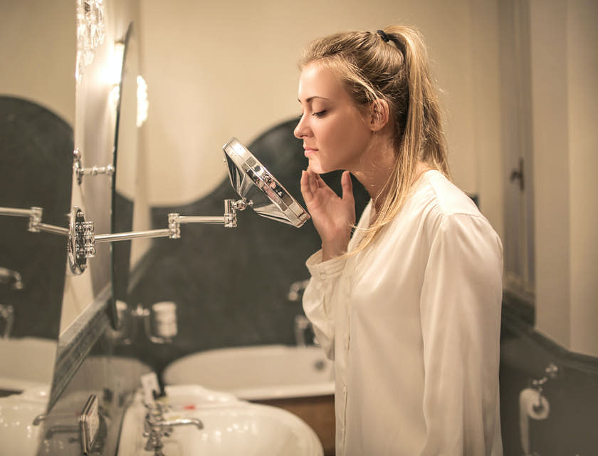 Une femme qui regarde son visage dans le miroir.