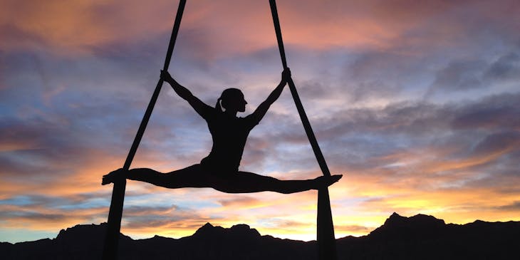 Woman performing aerial fitness exercise.
