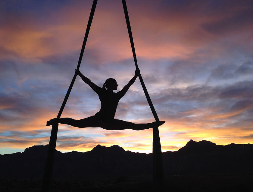 Mulher realizando exercícios de tecido acrobático.