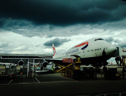 Avião de uma companhia aérea estacionado em uma pista ao lado de fora de uma empresa de aviação.