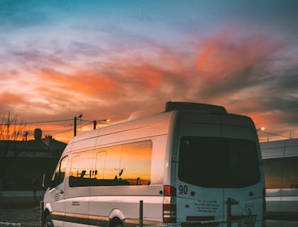 Una camioneta blanca de un una empresa de transportación al aeropuerto.