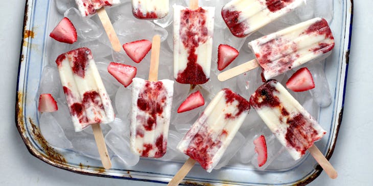 Alcoholic popsicles with strawberry pieces in an ice bucket.