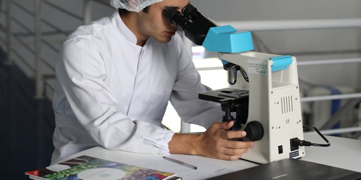 A doctor looking through a microscope.