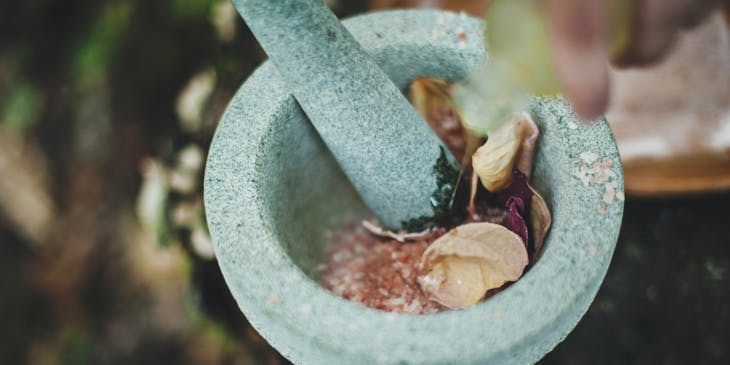 A mortar and pestle being used to make alternative medicine.