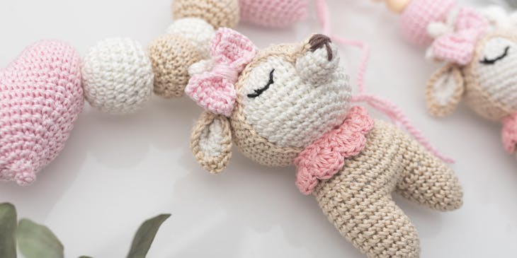 A cute pink, white, and light brown Amigurumi animal character toy