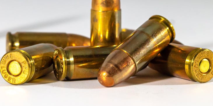 Gold bullets of an ammo on a white surface.