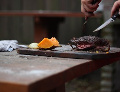 Un asado siendo preparado para clientes en un restaurante argentino.