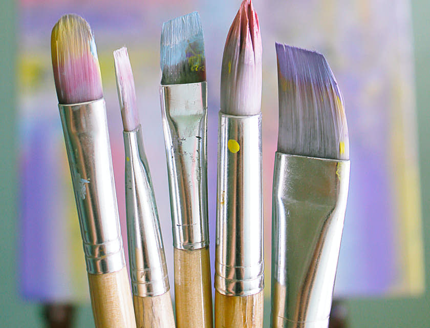 Pincéis com tintas coloridas em um curso de artes.
