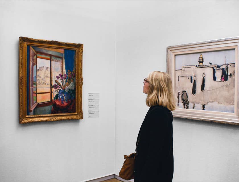 Une femme admire un tableau dans une galerie d'art.