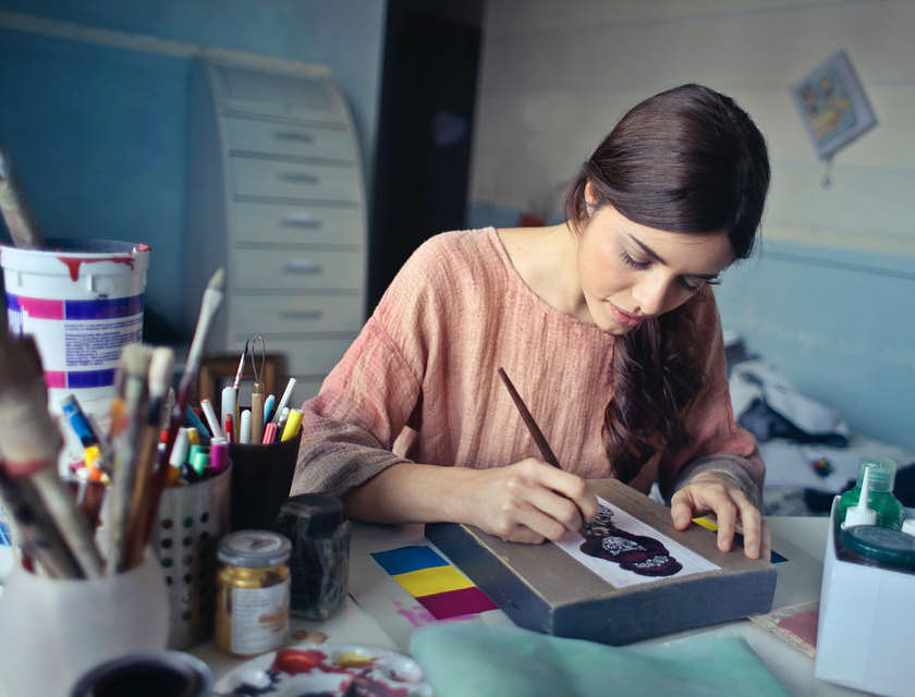 Una donna che dipinge durante un corso di art therapy.