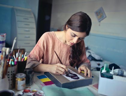 Une femme peignant au cours d'art-thérapie.