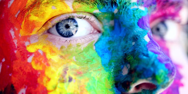 Artistic close up of man with colorful face paint.