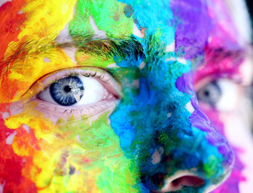 Artistic close up of man with colorful face paint.
