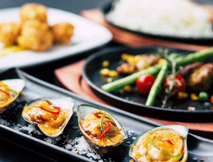 Multiple Asian dishes on a table at an Asian fusion restaurant.
